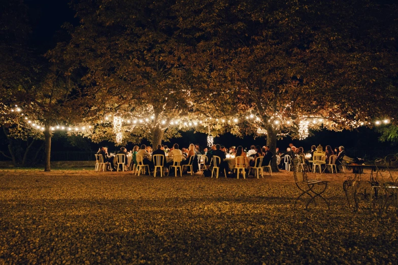 people are gathered for an outdoor party at night