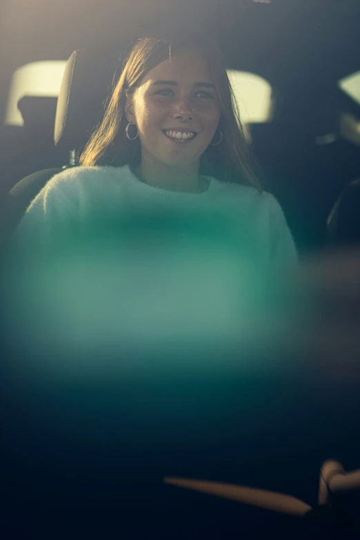 a woman smiles while sitting in the back seat of a car