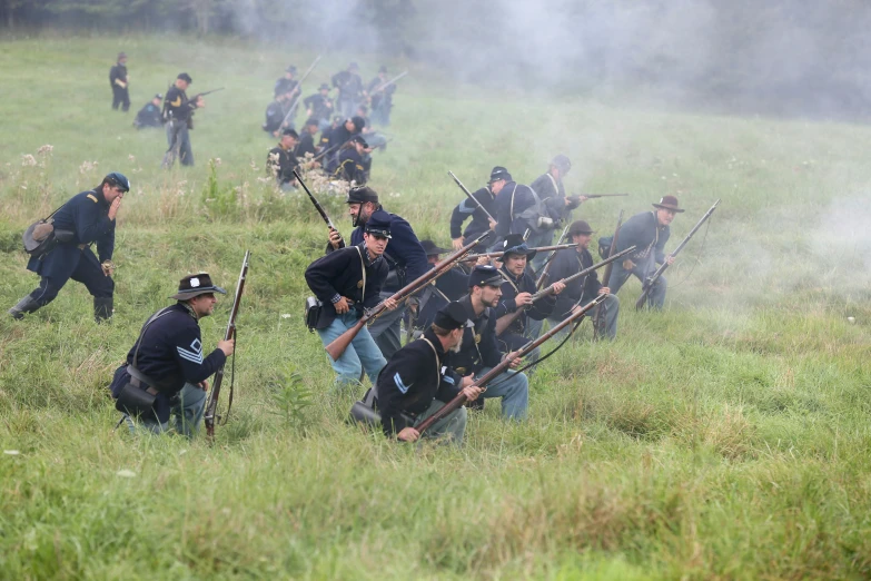 many men with long sticks are running through the grass