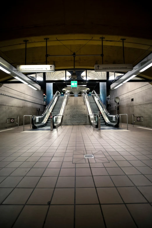 an escalator leading to several platforms at night