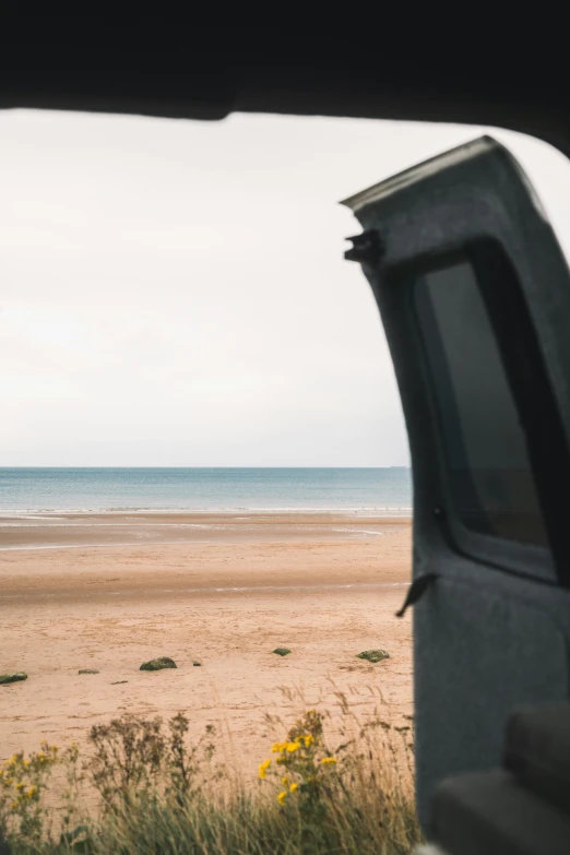 a truck is at the beach with the back window open