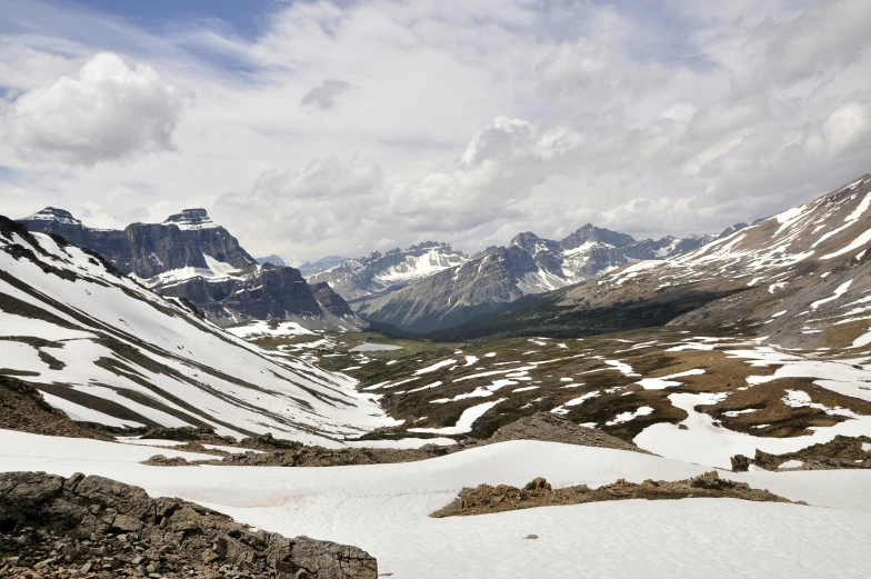 a group of snow covered mountains with white clouds