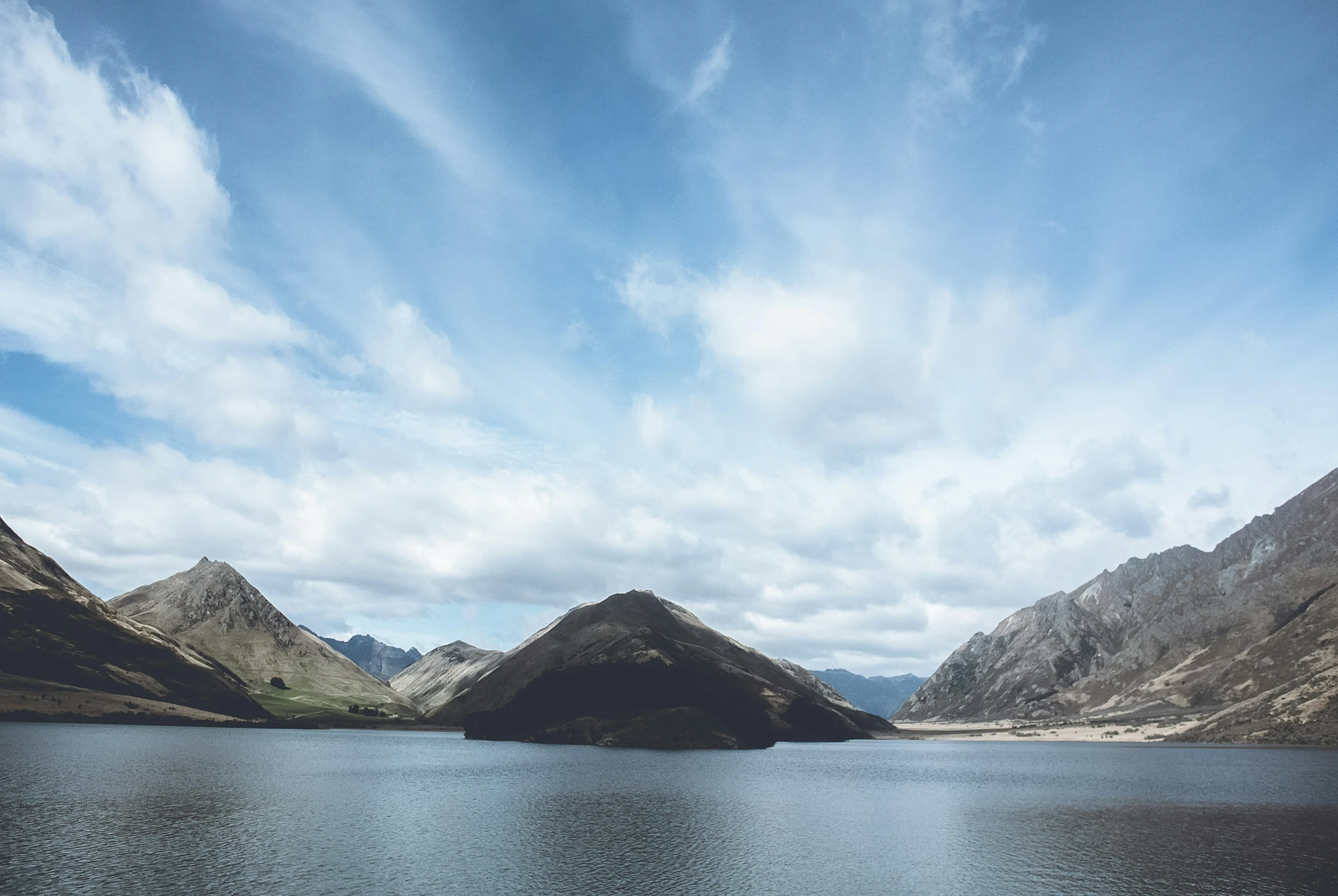 several small mountains near a lake in the middle of nowhere