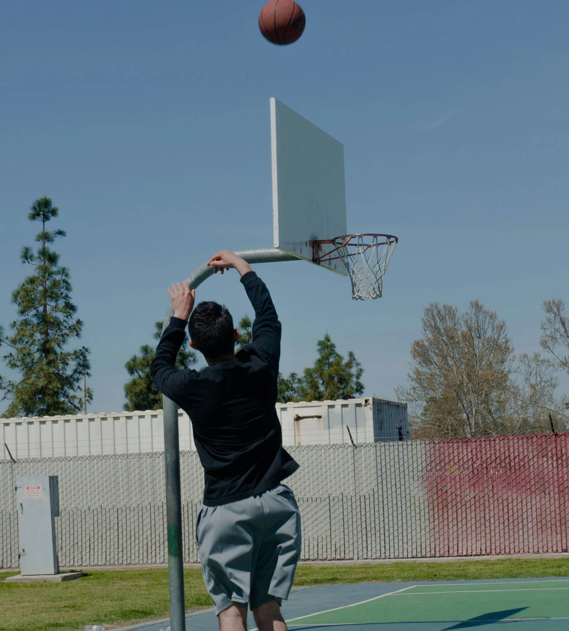 a man throwing a basketball over a goal