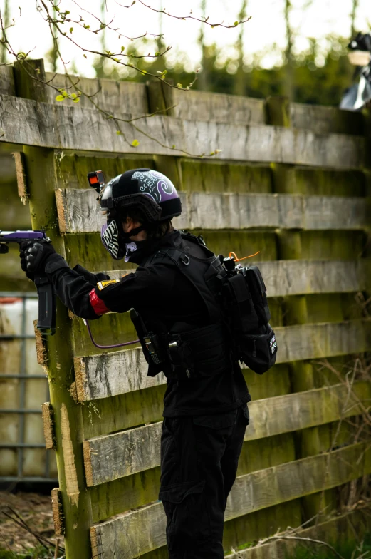 a person in black clothes holding a gun up to an air rifle