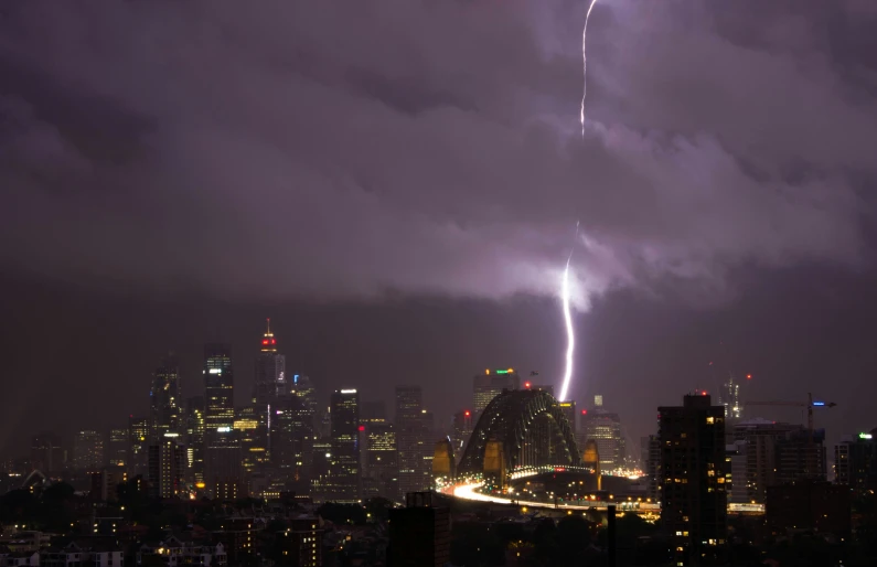 a large storm moving across the night sky in a city