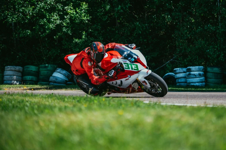 a motorcyclist rides a race bike near some tires