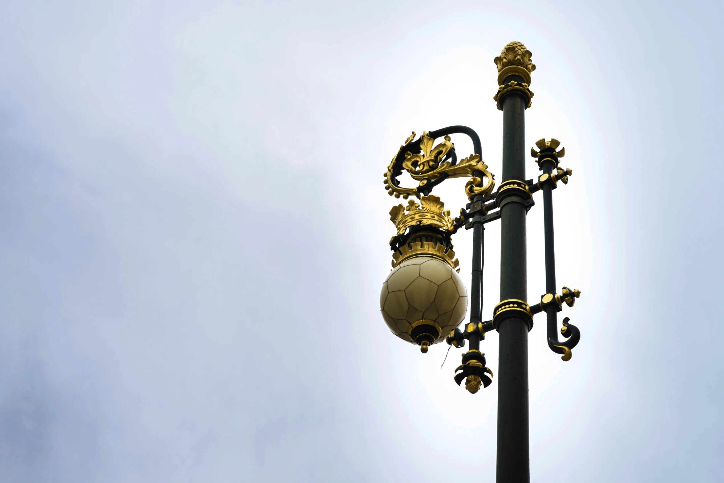 a gold lamp that is sitting next to a pole