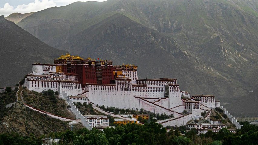 a white and red building surrounded by mountains