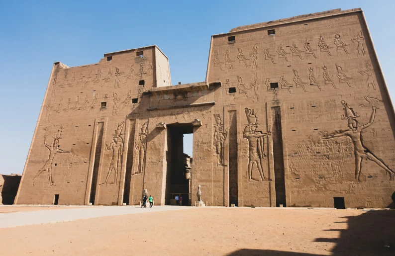 a po of an egyptian temple with two people standing in front
