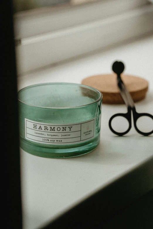 a jar of beauty product and scissors on a counter