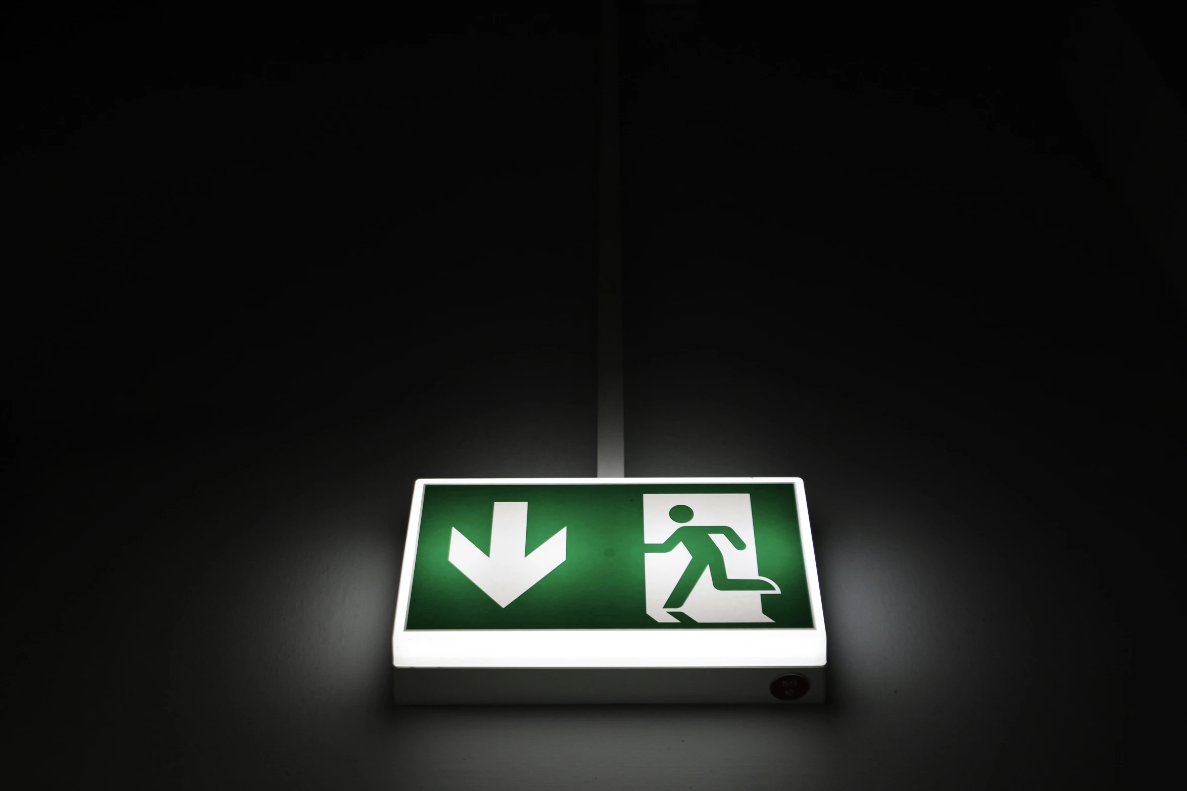 a green sign with a white arrow and man