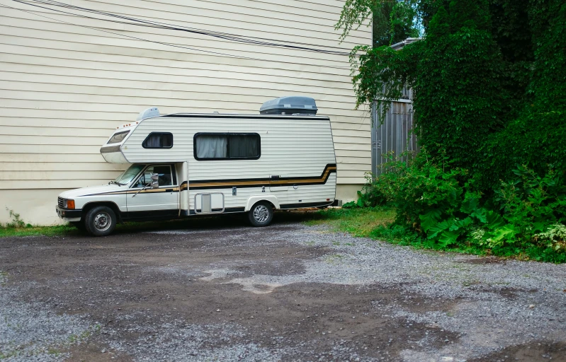 a parked rv next to the side of a house