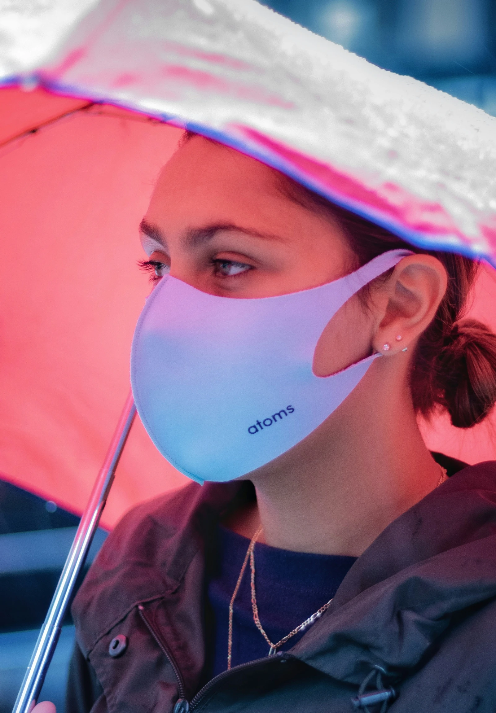 the woman wears a pink and white mask