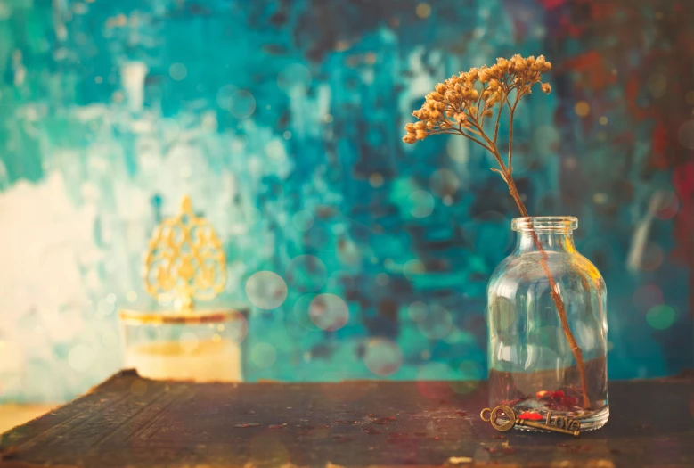 a vase is holding a yellow flower and has small yellow stems