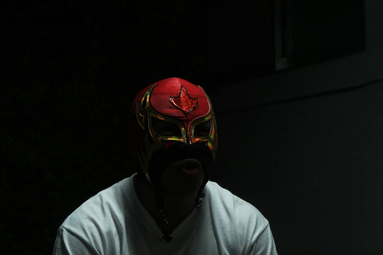 a man wearing a red helmet in a dark room