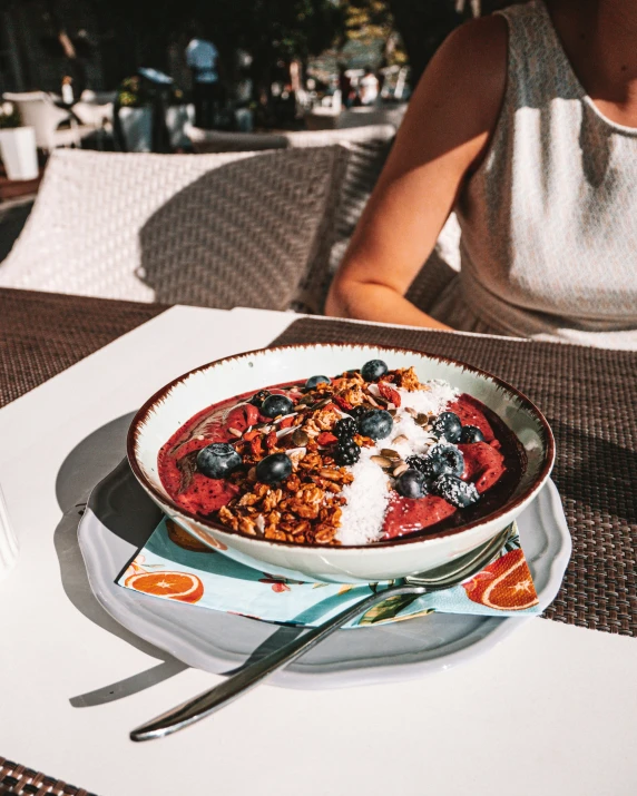 the plate of food is near the fork on the table