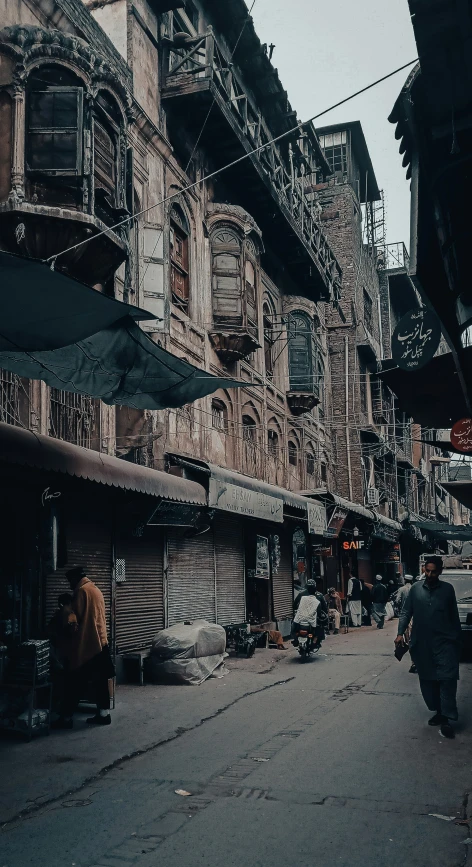 a woman walking down a narrow road between two buildings