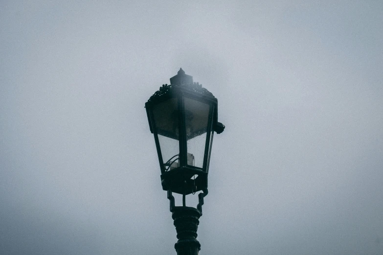 a light on top of a pole in the fog