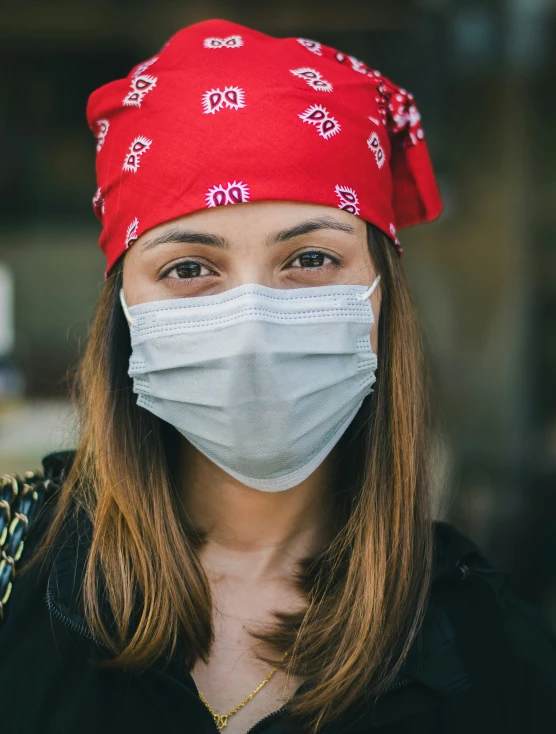 the woman wears a face mask with red bandana