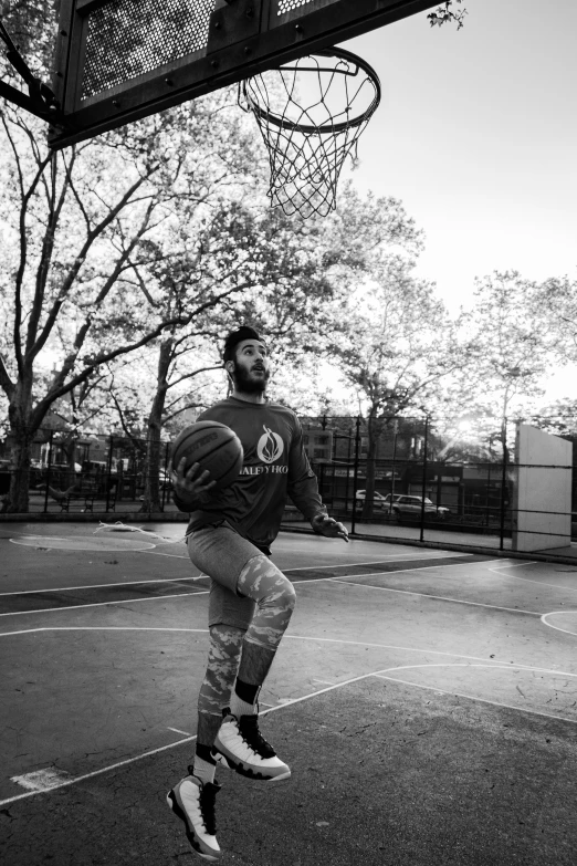 a man is playing basketball outside by himself