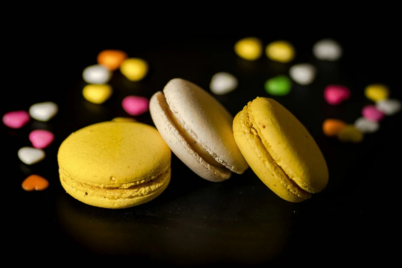 two macaroons are sitting next to each other on a black surface