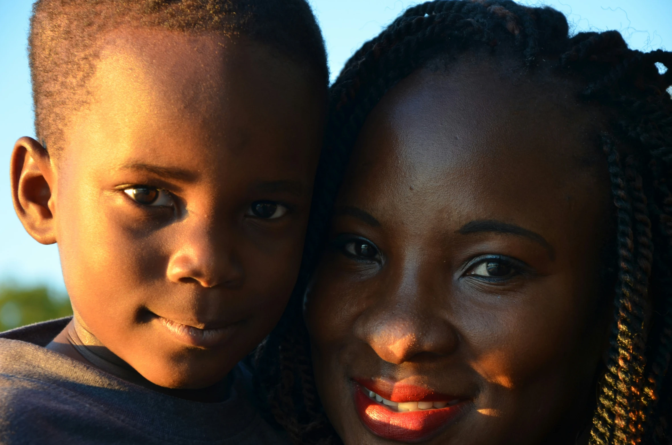 a girl and a boy posing together in front of a sky