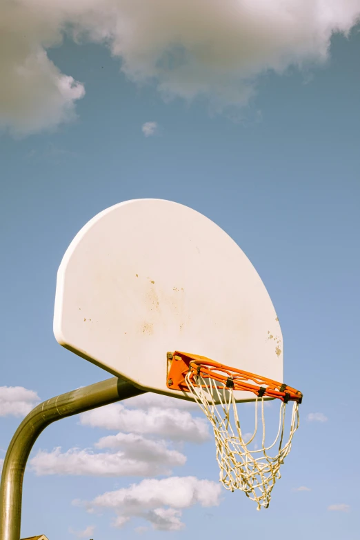 a white basketball hoop and its net on a sunny day