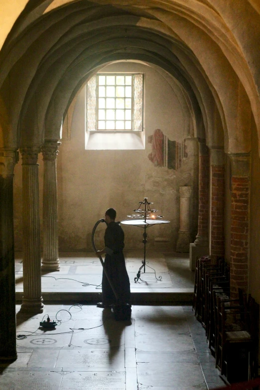 a woman in a medieval looking building holding a sword