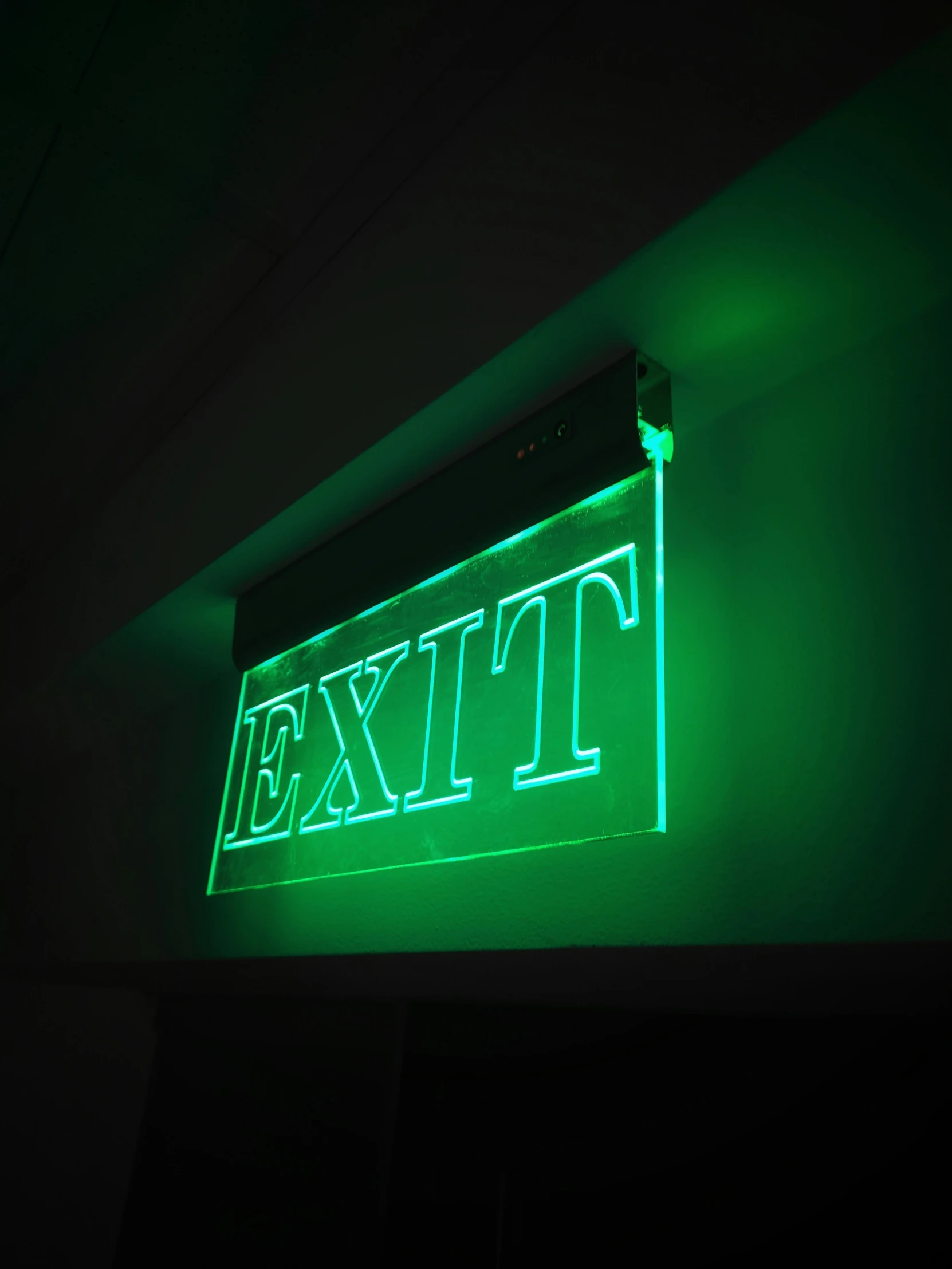 neon sign in the dark that says exit