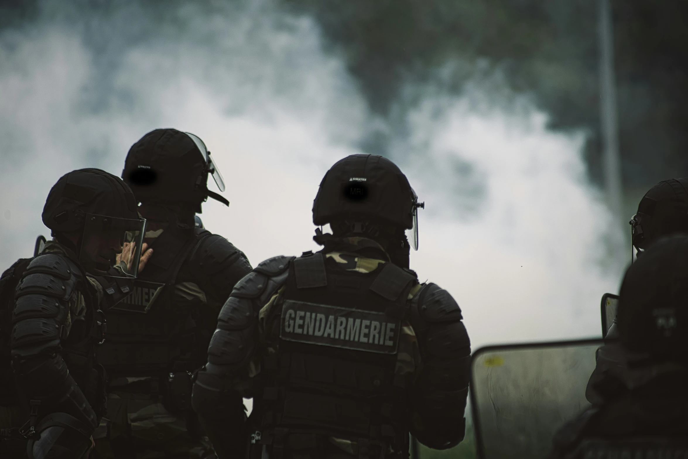 group of firefighters with helmets and vests standing next to building