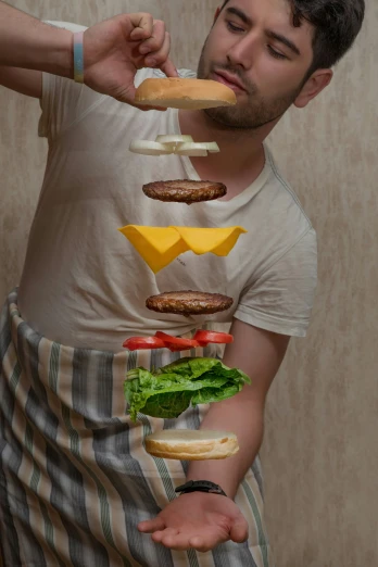 the man in the apron is balancing food on his fingers
