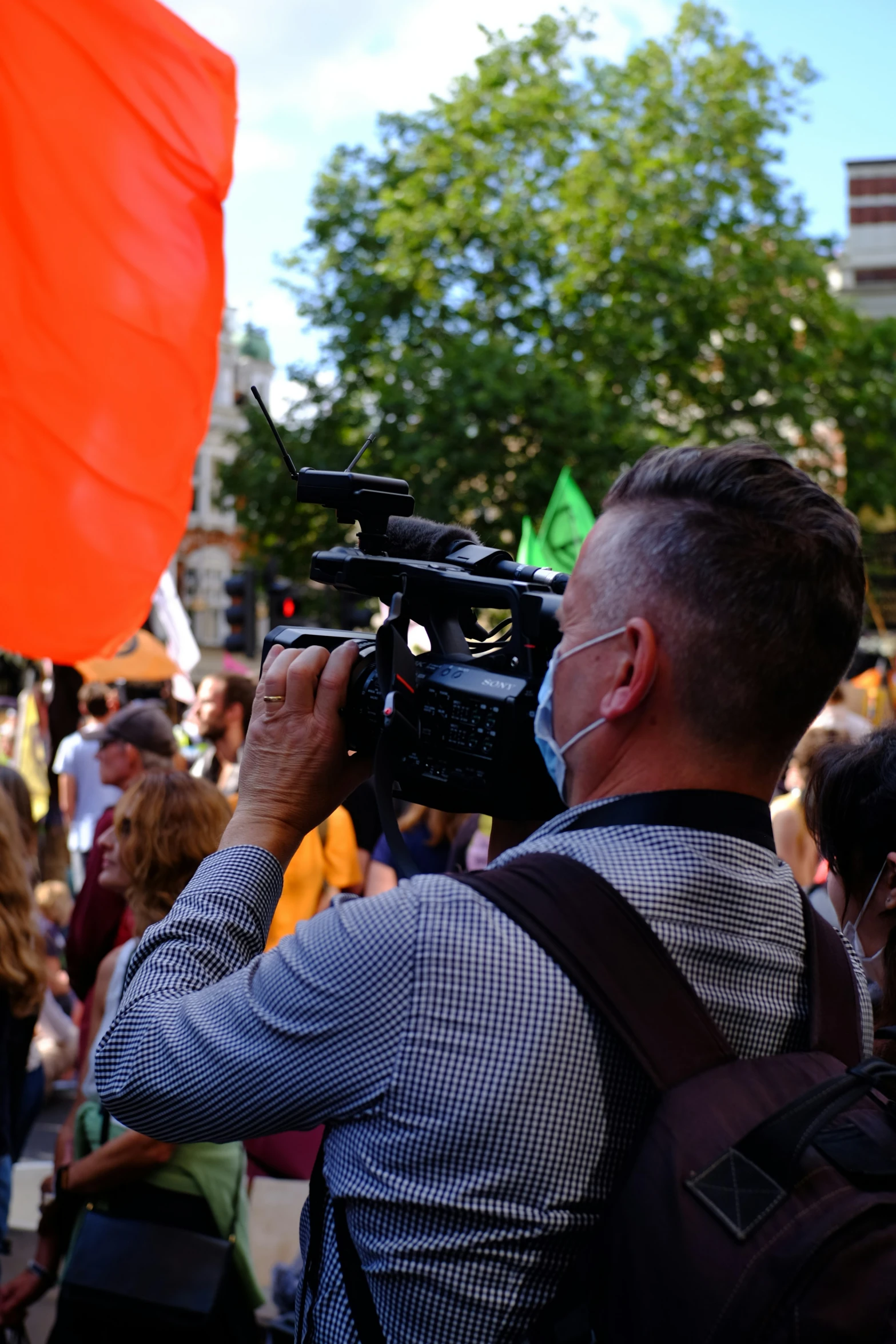 a man with a camera next to a crowd