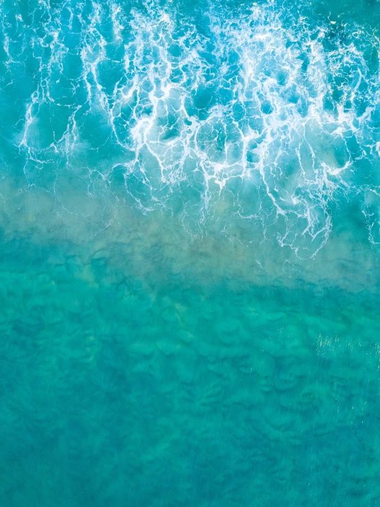 an aerial view of a blue ocean with large waves