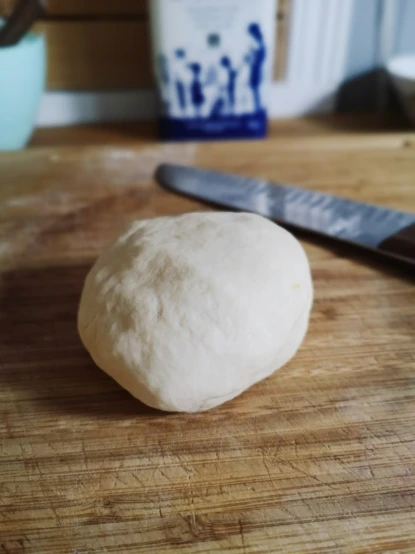 a small ball of dough next to a knife