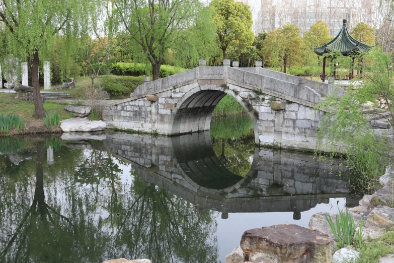 an old stone bridge surrounded by a pond