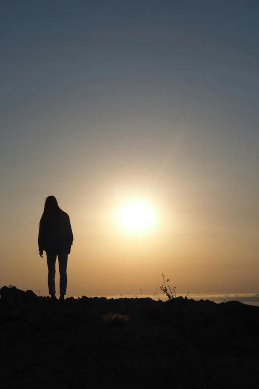 a person silhouetted in the sky during the sun set