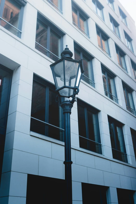 a tall light post sitting in front of a white building