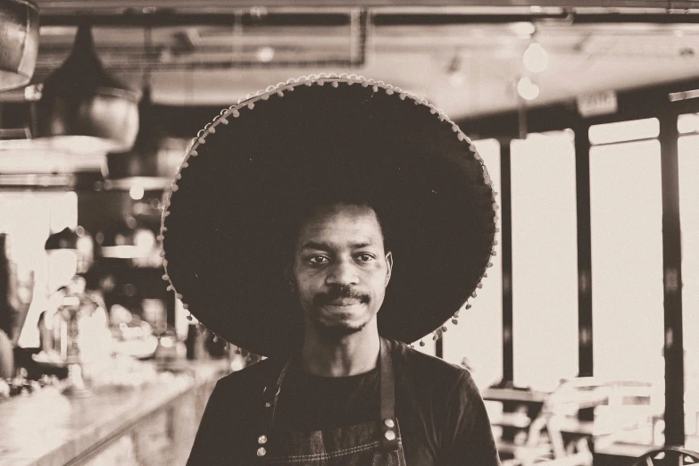 a man with a large afro standing behind a counter