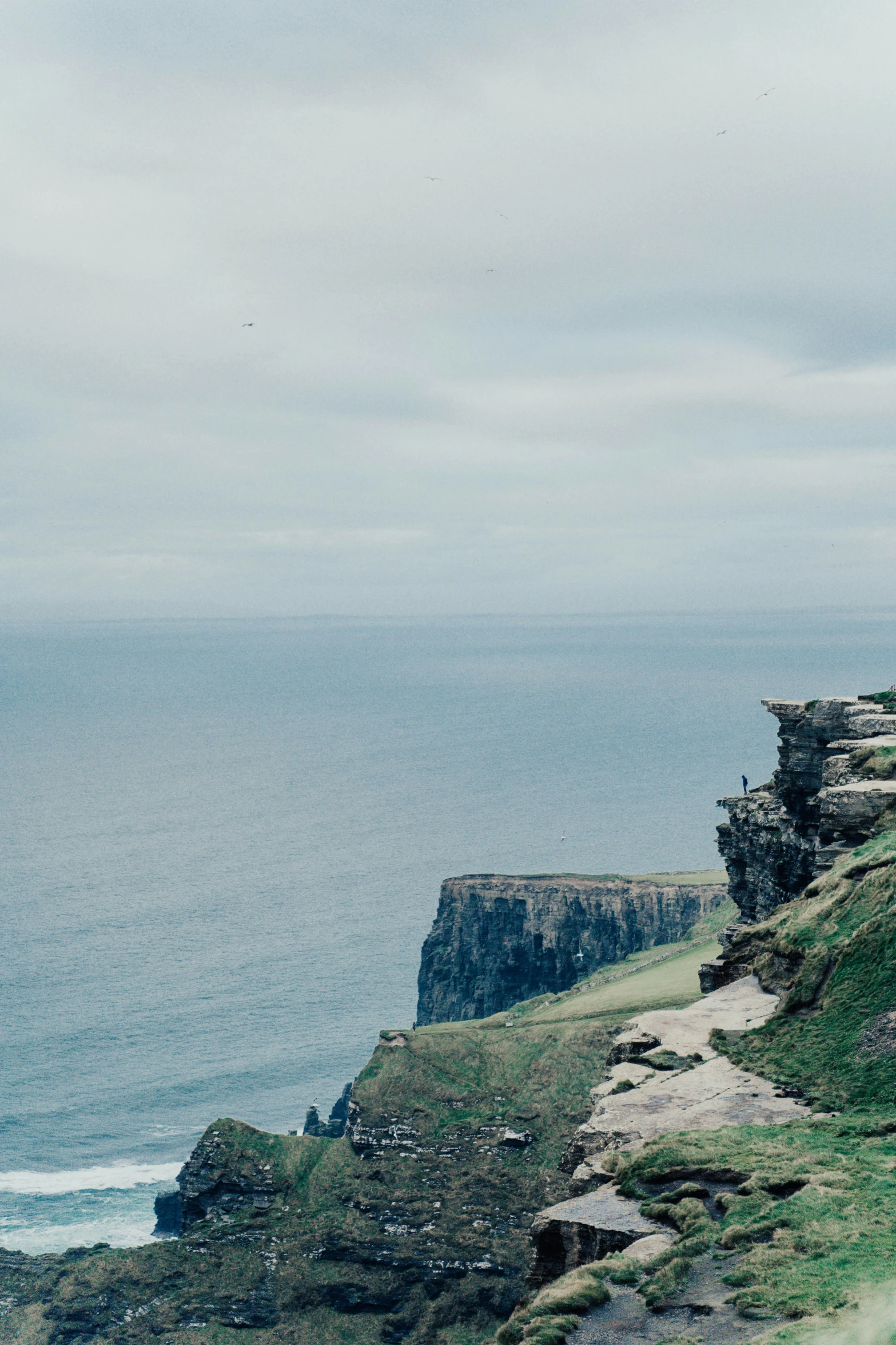 a bench on the edge of a cliff over looking a body of water