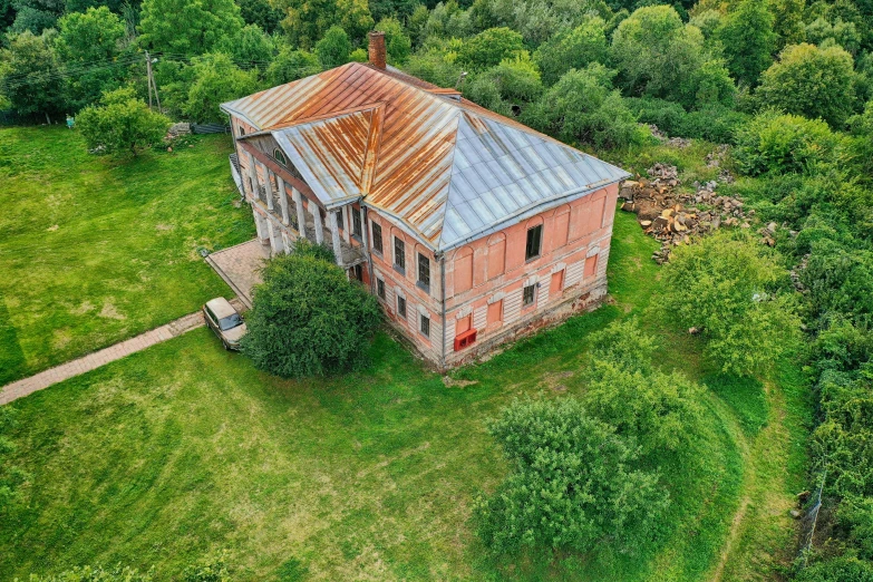 an old, run down house in the middle of a grassy area