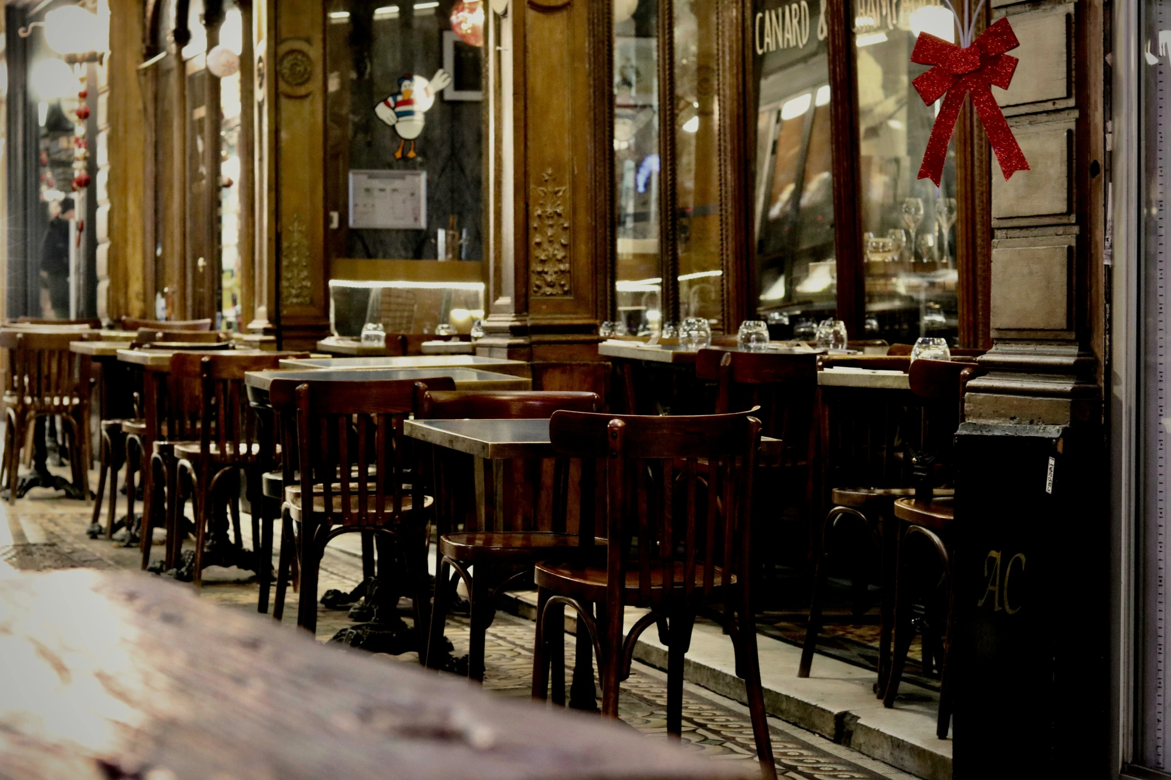 a row of wooden tables with chairs at each side