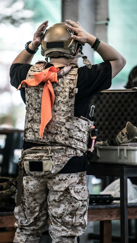 the back view of an army soldier putting on his helmet