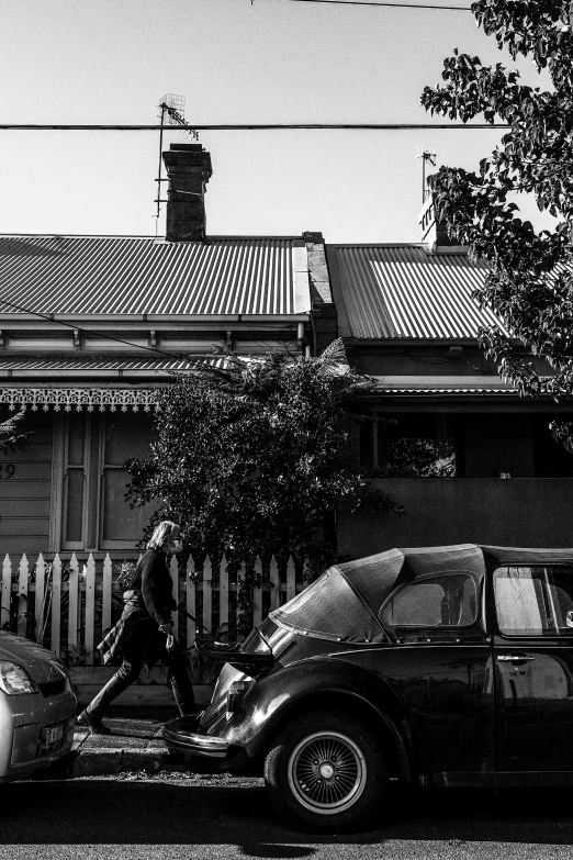 a dark black and white po with two cars and a building