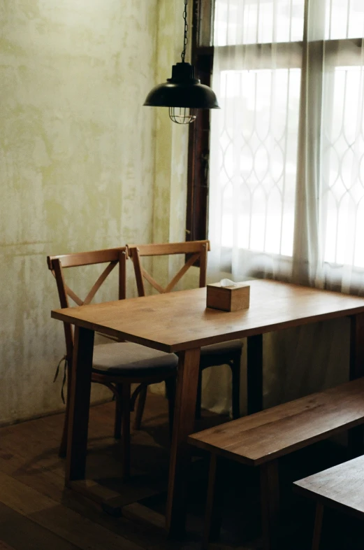 a dining room table with benches and a light