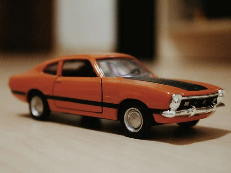 an orange model car sits on a table