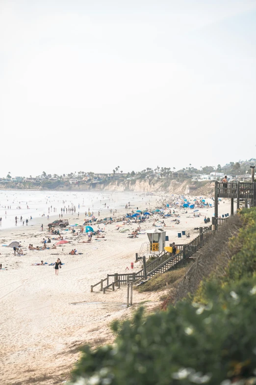 a crowded beach with many people and umbrellas