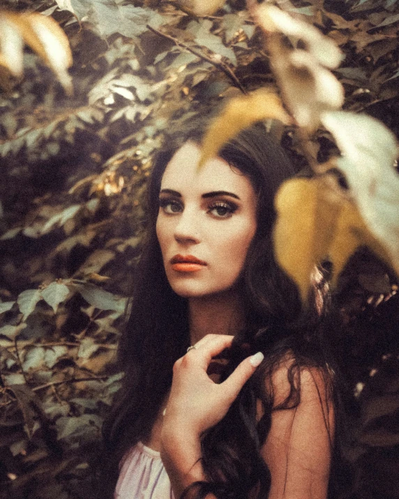 woman wearing dress in front of trees and leaves