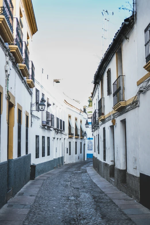 a narrow street in front of tall white buildings