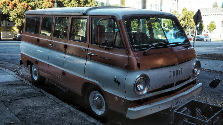 a brown and grey van is parked on the sidewalk